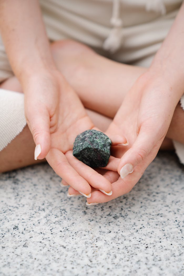 Crafting Captivating Headlines: Your awesome post title goes here Close-up of hands gently holding a healing gemstone during meditation.