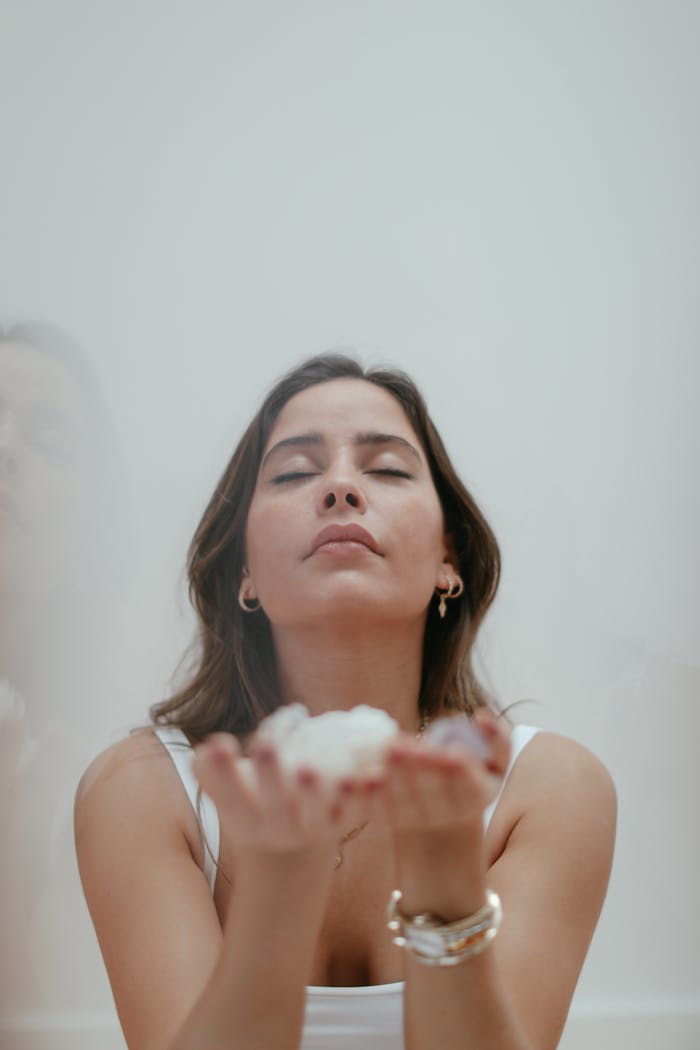 An adult woman with closed eyes, embracing calmness, demonstrating mindfulness practice in a serene setting.